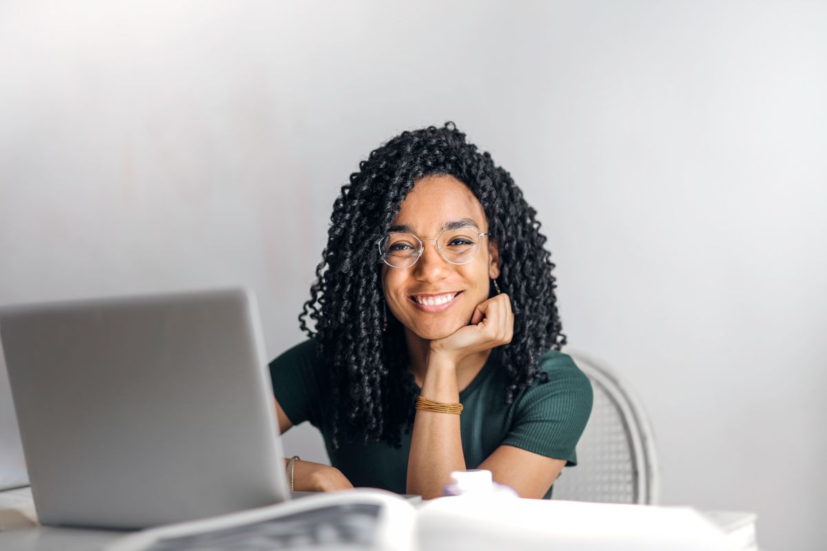 A professional smiling at her laptop